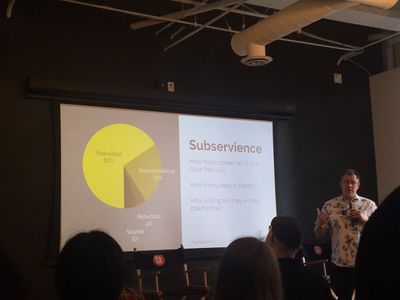 A man presents a slide with the content, 'Subservience: How many screen sci-fi AIs have free will? How many obey a master? How willing are they in their obedience?' with a pie chart where it was 66% freewilled, 25% improvisational, 5% slavish, 4% reluctant.'