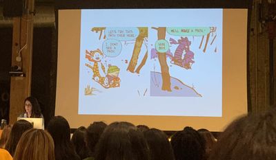 Nisa stands in front of her slide, displaying two panels from the Calvin and Hobbes comic strip where Hobbes says he doesn’t seen a path ahead on their sled, but Calvin says they’ll make one.